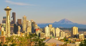 The Seattle Skyline including Space Needle, and Mount Rainier change colors at golden hour and sunset on a beautiful summer evening.